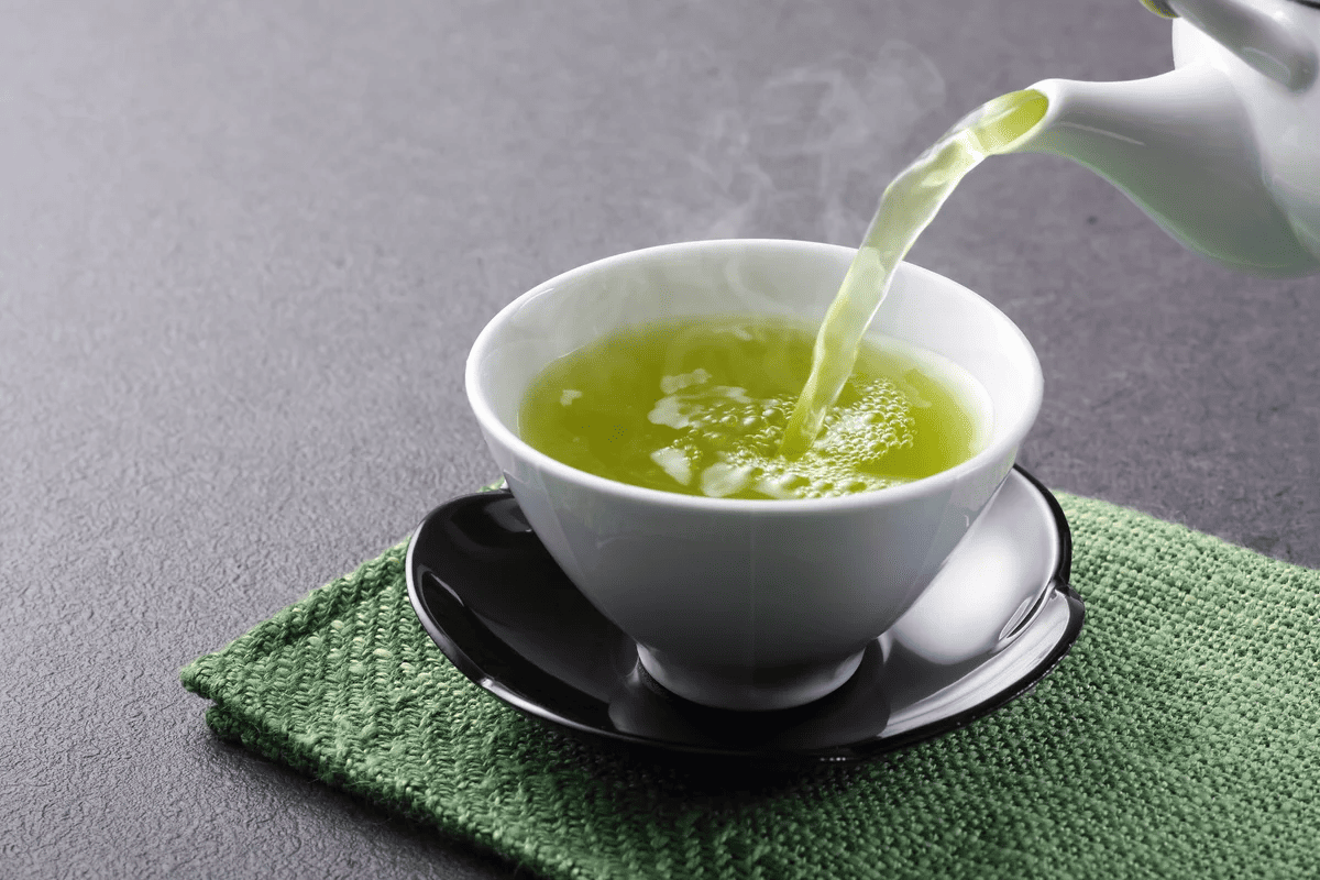 Hot green tea poured into a cup