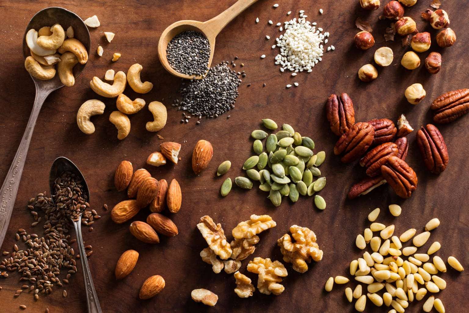 Assorted nuts and seeds on a wooden table